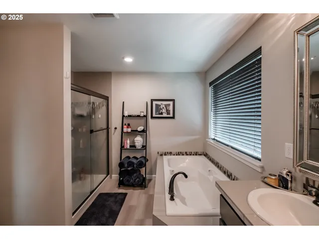 a en suite bathroom with a tub sink and mirror