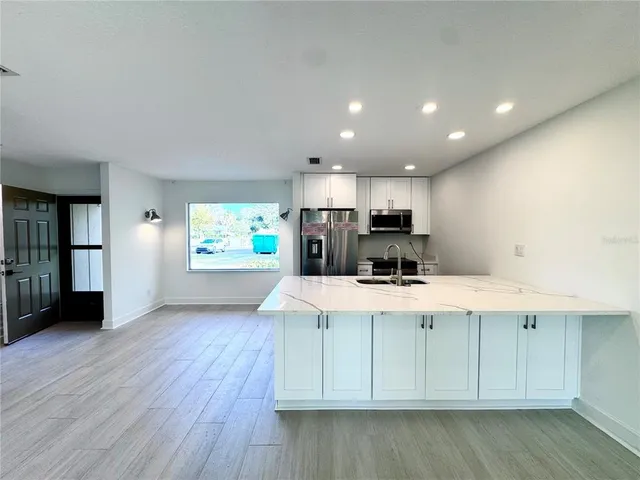 a bathroom with a granite countertop sink a toilet and shower
