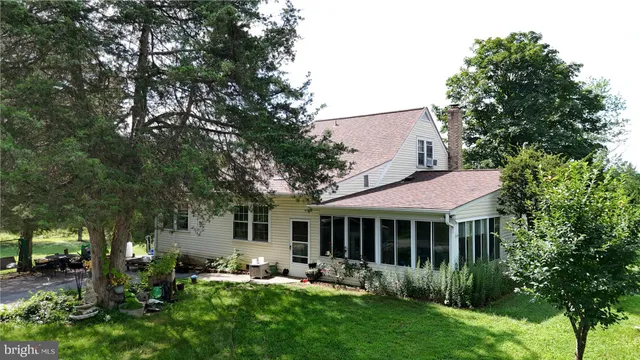 a view of a house with backyard garden and sitting area