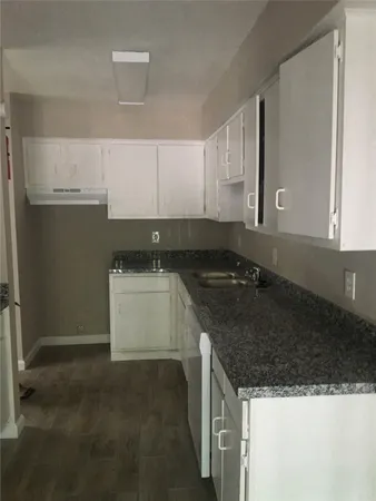 a kitchen with granite countertop a sink and a stove
