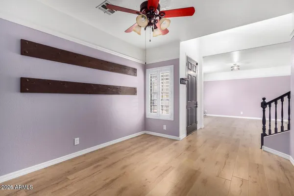 a view of a livingroom with a chandelier fan and wooden floor