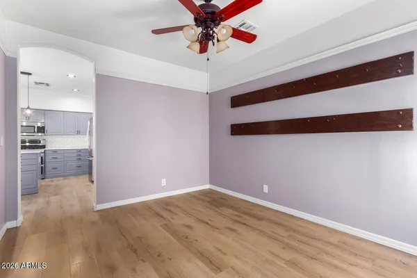 a view of an empty room with wooden floor and stairs