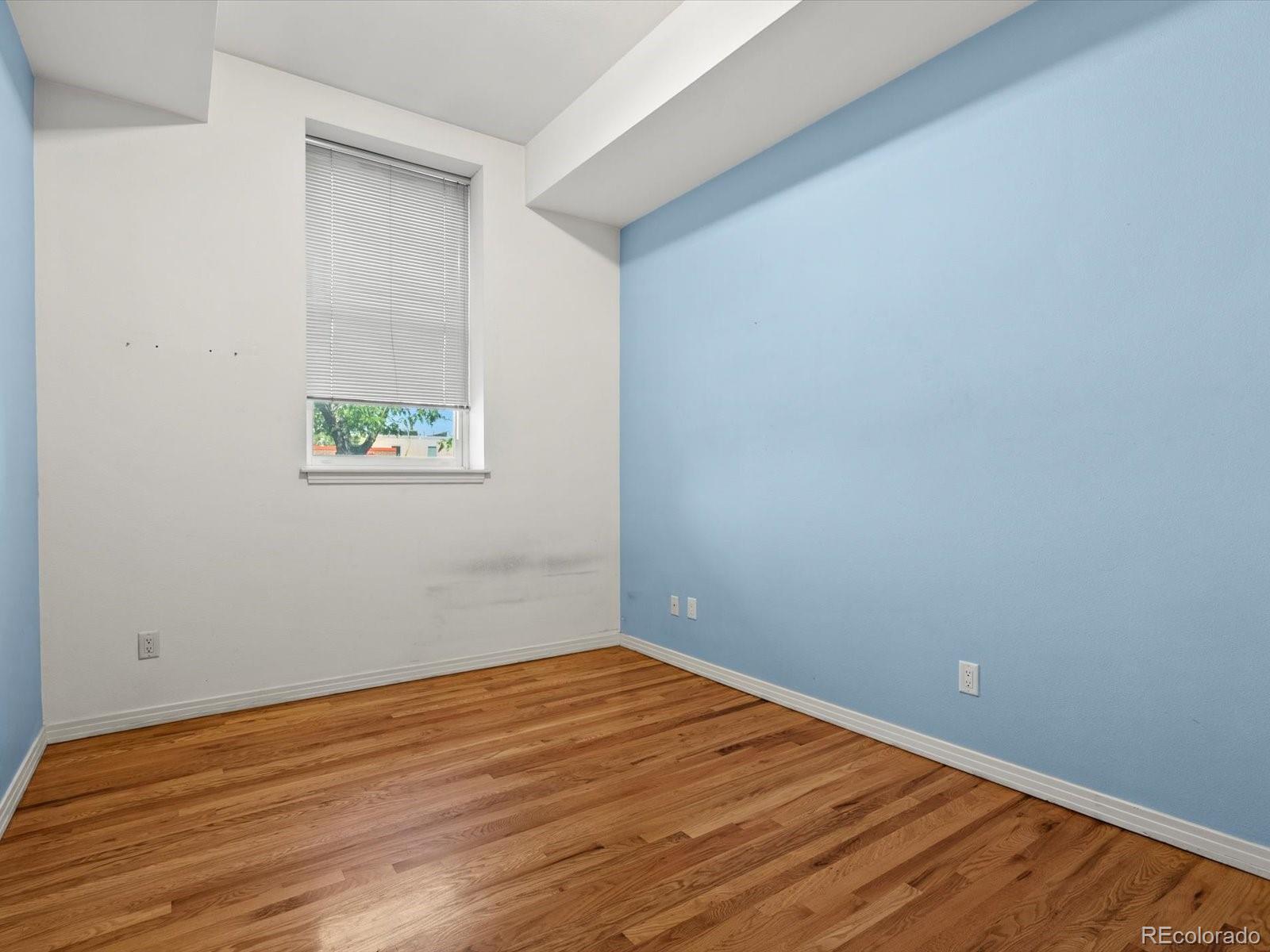 225 Lincoln Street, Unit 4 Denver, CO 80203 - Photo 13 of 34 a view of an empty room with wooden floor and a window