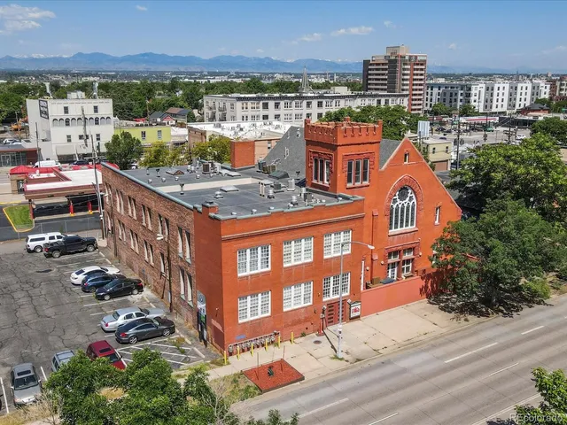 a kitchen with stainless steel appliances granite countertop a stove a sink dishwasher and a dining table with wooden floor