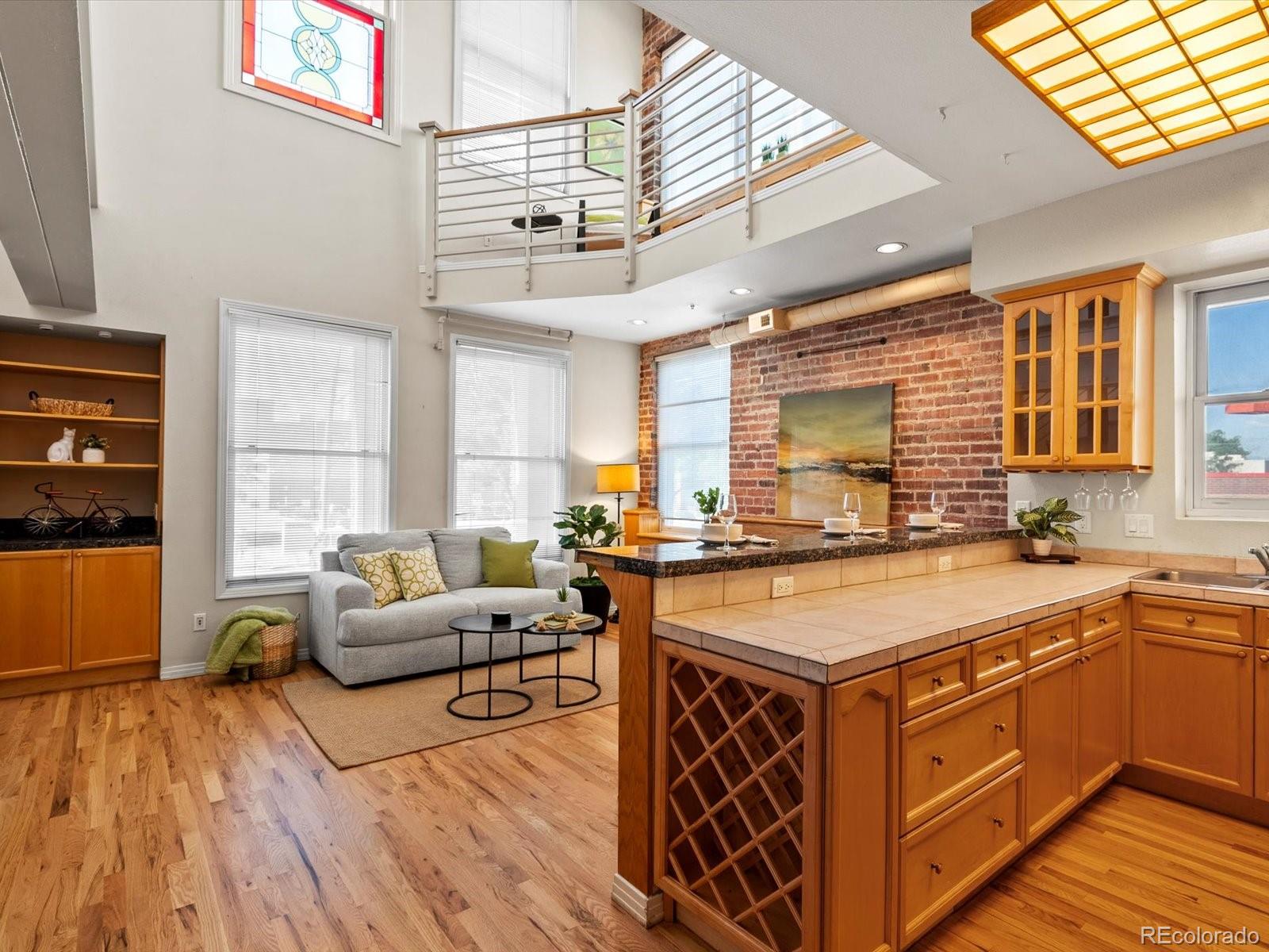 225 Lincoln Street, Unit 4 Denver, CO 80203 - Photo 3 of 34 a kitchen with stainless steel appliances granite countertop a stove a sink dishwasher and a dining table with wooden floor