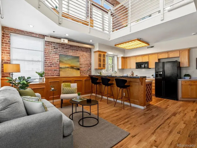 a kitchen with a refrigerator a sink dishwasher a stove and a dining table with wooden floor