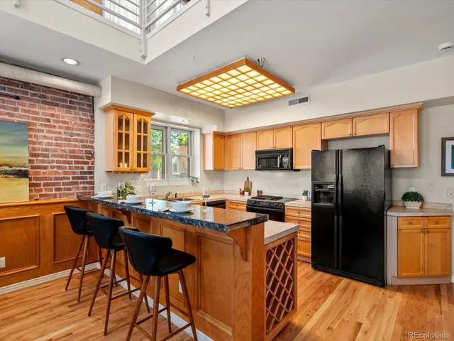 a kitchen with stainless steel appliances granite countertop a sink a stove a oven a counter space and cabinets