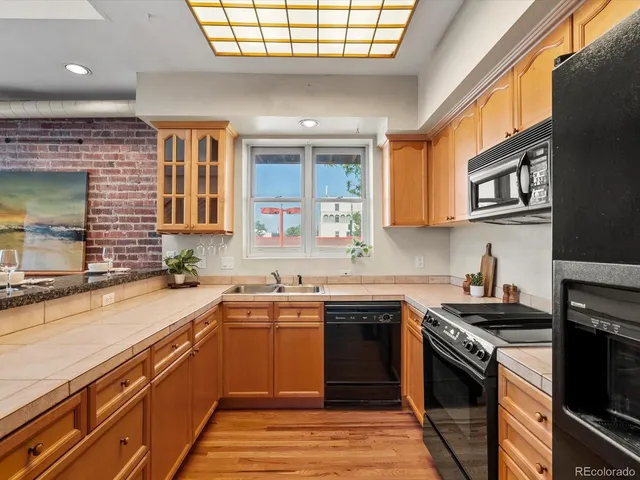 a kitchen with stainless steel appliances granite countertop a sink a stove and a refrigerator