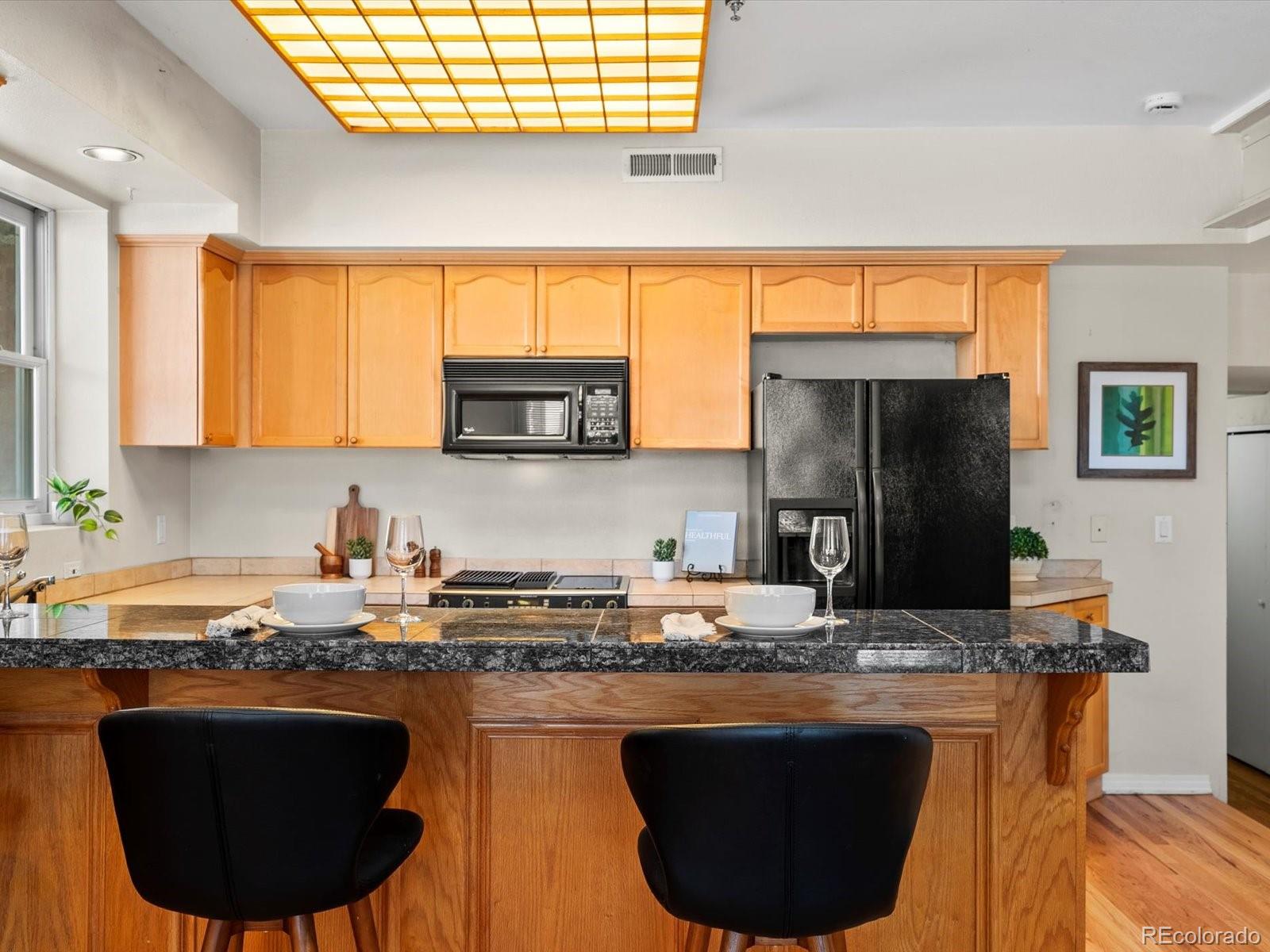 225 Lincoln Street, Unit 4 Denver, CO 80203 - Photo 9 of 34 a kitchen with stainless steel appliances granite countertop a sink a stove and a refrigerator