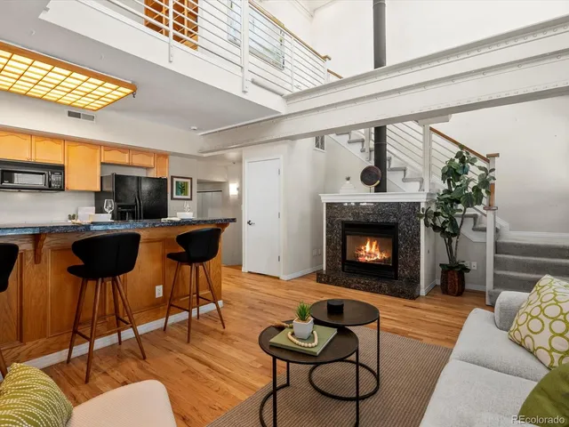 a view of an empty room with wooden floor fireplace and a window