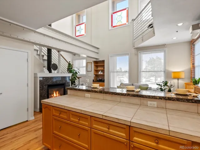 a view of an empty room with wooden floor fireplace and a window
