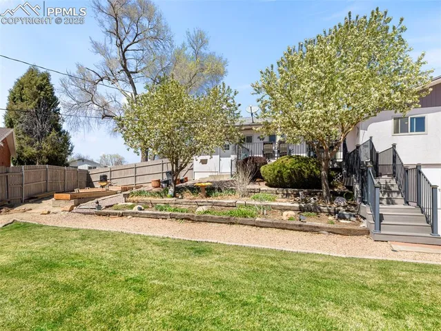 a patio table and chairs with potted plants and wooden fence