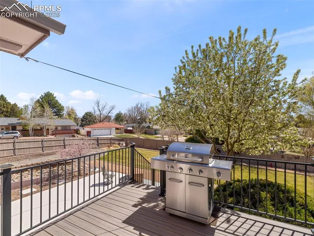 a view of a roof deck with table and chairs with wooden floor and fence