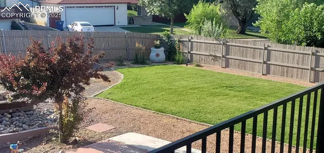 a view of backyard of house and car parked