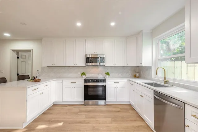 a kitchen with a sink white cabinets and white appliances