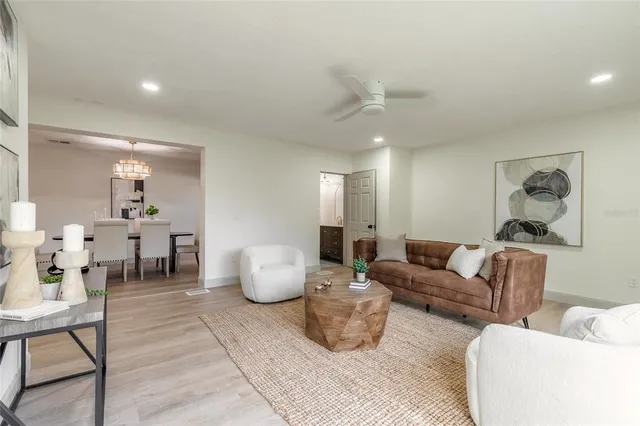 a living room with furniture and a dining table with kitchen view