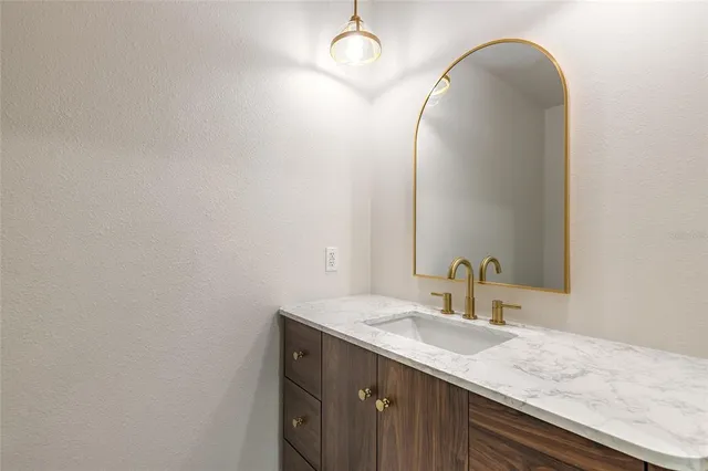 a bathroom with a granite countertop toilet and a sink