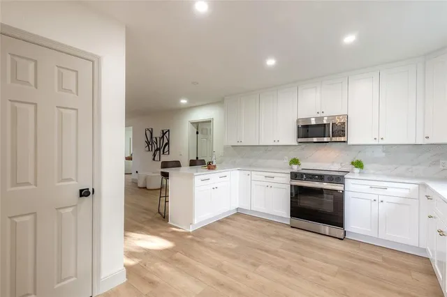 a kitchen with white cabinets and appliances