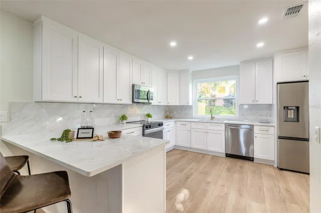 a kitchen with a refrigerator sink and white cabinets