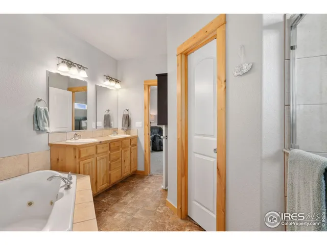 a bathroom with a tub a sink a mirror and a shower