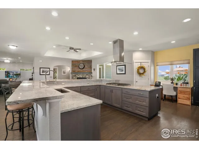 a kitchen with stainless steel appliances granite countertop a kitchen island a stove and a sink