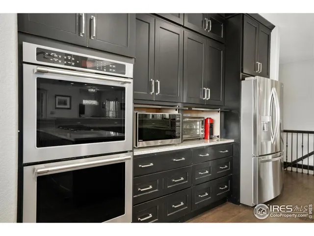 a kitchen with stainless steel appliances granite countertop a refrigerator and a stove