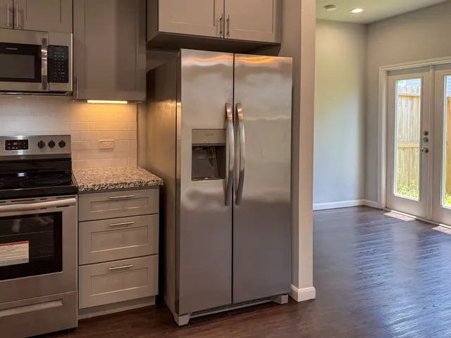 a kitchen with appliances a counter space and cabinets