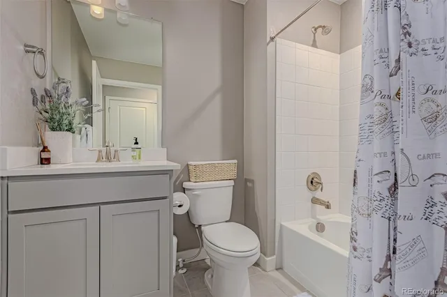 a bathroom with a sink a toilet a mirror and shower curtain