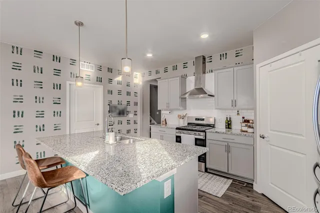 a kitchen with kitchen island granite countertop a sink a counter top stainless steel appliances and cabinets