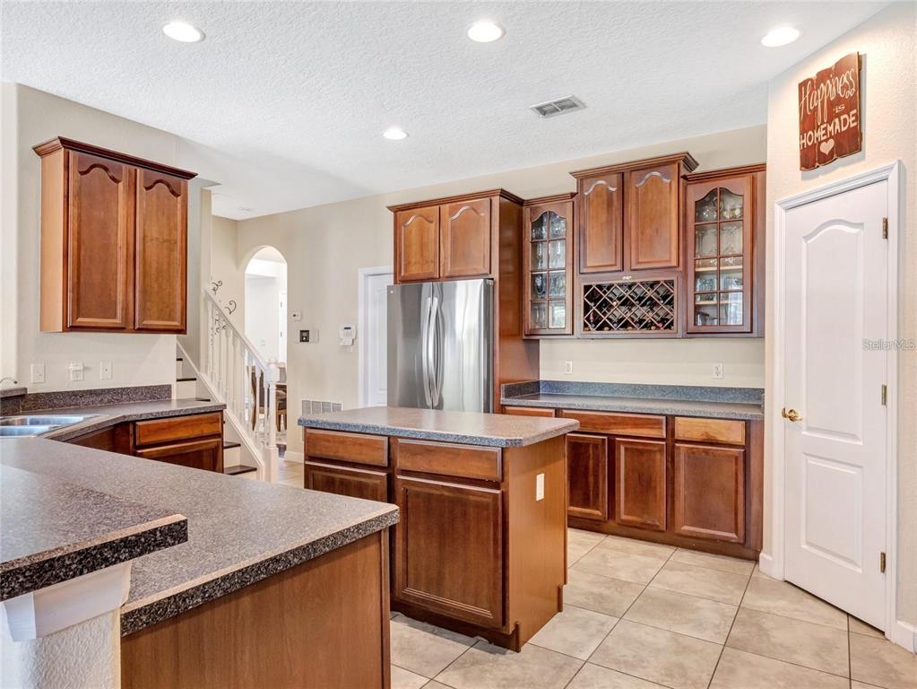 10023 Ians Ridge Road Orlando, FL 32832 - Photo 19 of 60 a kitchen with stainless steel appliances granite countertop a sink and a refrigerator