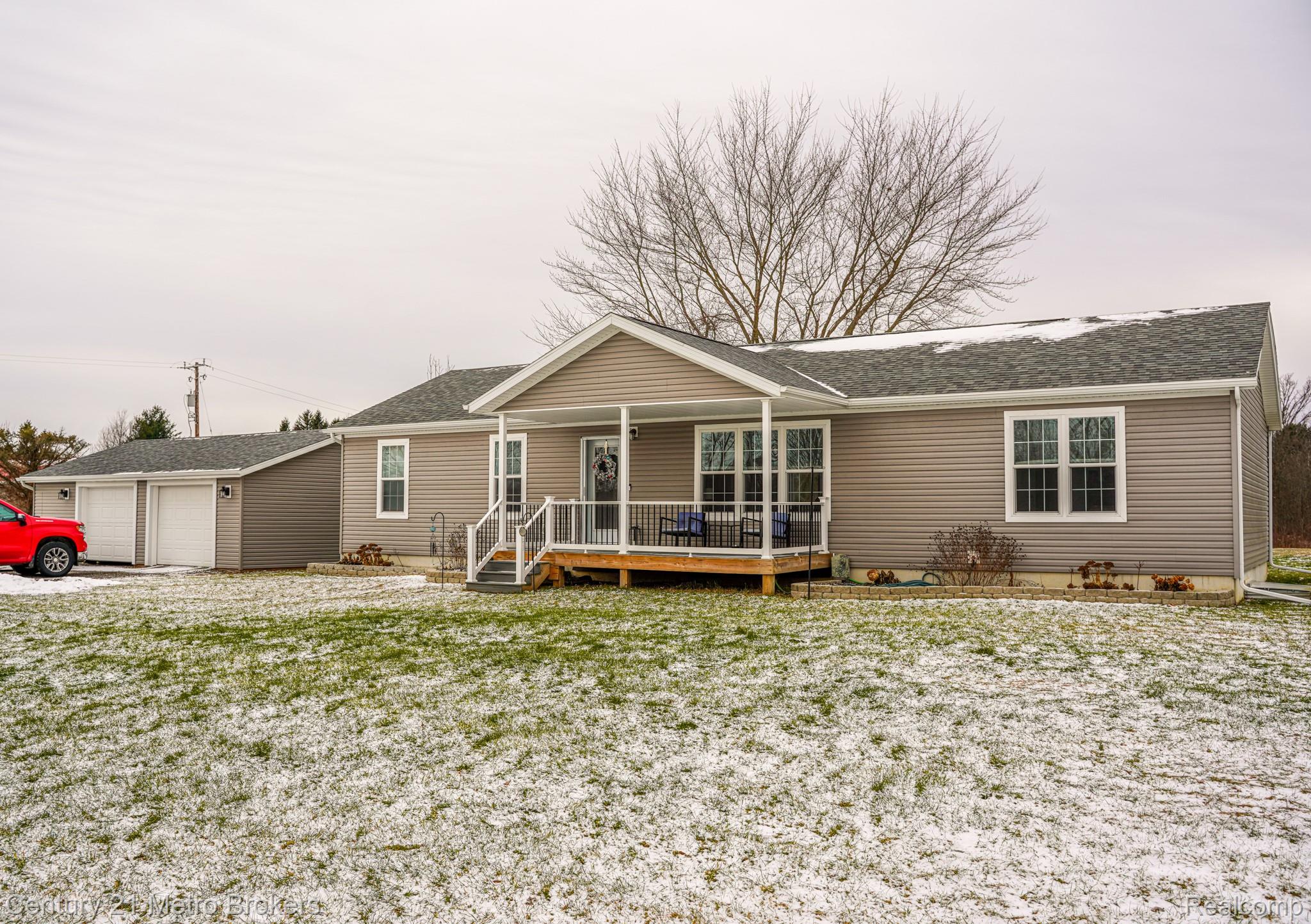 6449 Oliver Road Fostoria, MI 48435 - Photo 1 of 17 Single story home featuring roof with shingles, a wooden deck, and a garage