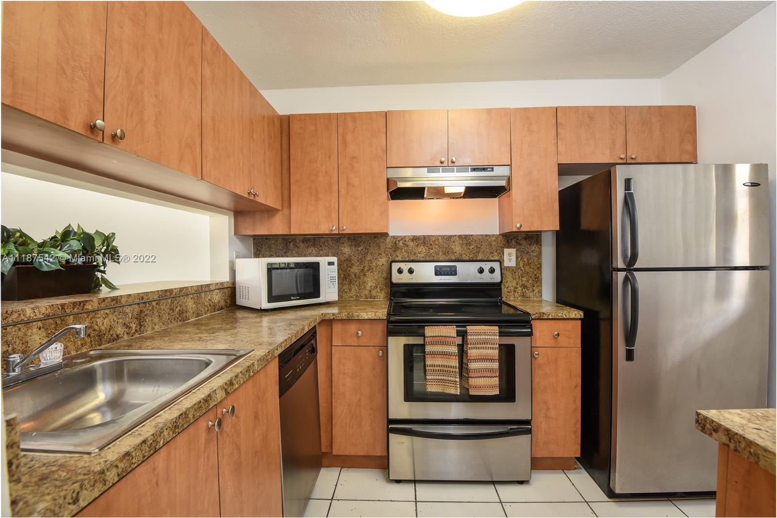3199 Foxcroft Road, Unit 304 Miramar, FL 33025 - Photo 1 of 35 a kitchen with stainless steel appliances granite countertop a refrigerator stove and sink