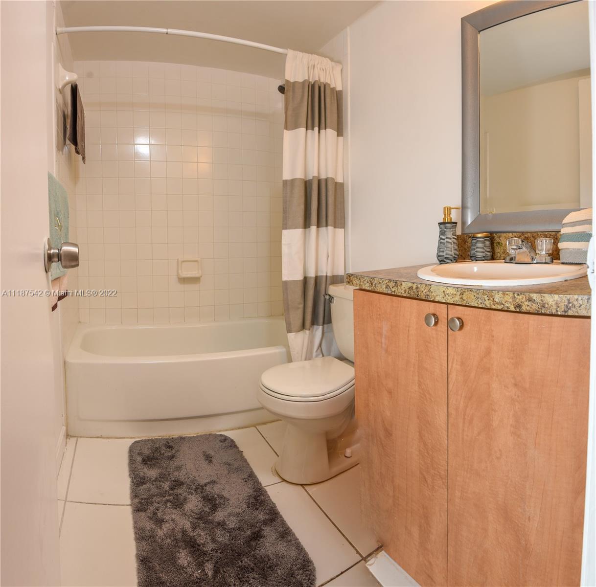 3199 Foxcroft Road, Unit 304 Miramar, FL 33025 - Photo 11 of 35 a bathroom with a granite countertop sink a toilet a mirror and shower