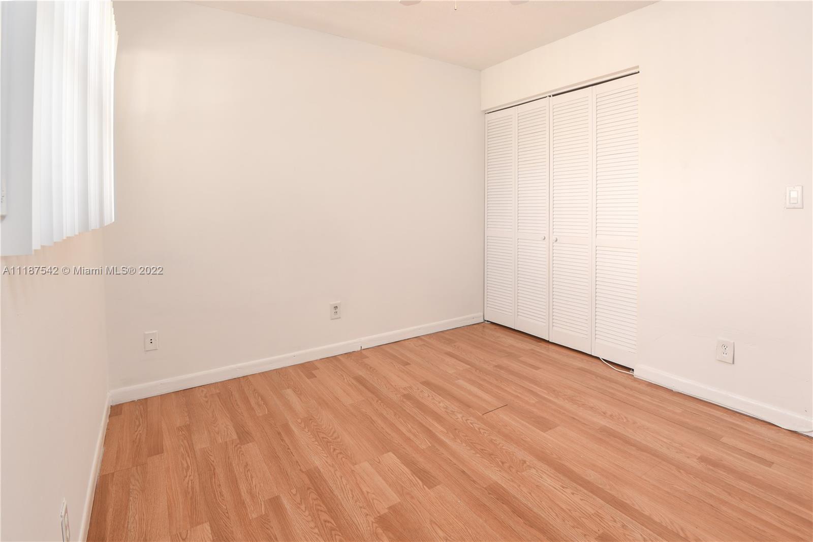 3199 Foxcroft Road, Unit 304 Miramar, FL 33025 - Photo 13 of 35 a view of an empty room with wooden floor and a window
