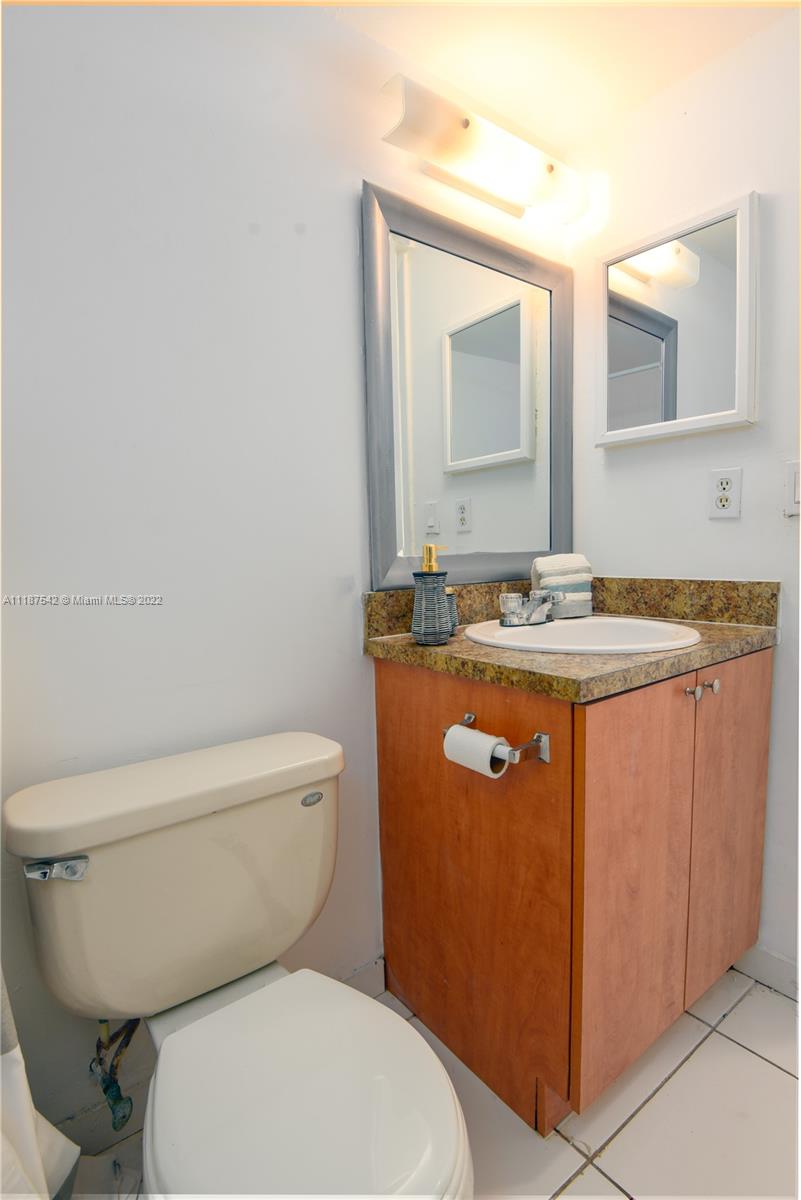 3199 Foxcroft Road, Unit 304 Miramar, FL 33025 - Photo 16 of 35 a bathroom with a toilet a sink and mirror