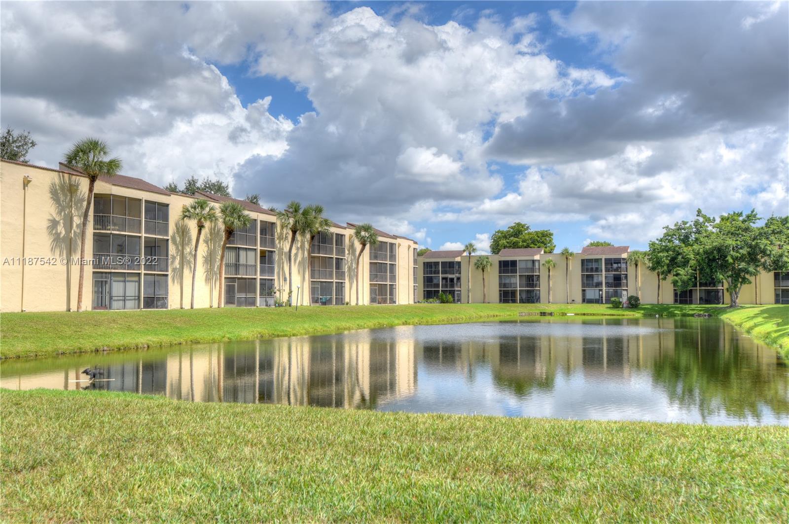 3199 Foxcroft Road, Unit 304 Miramar, FL 33025 - Photo 31 of 35 a view of a house next to a lake with a big yard