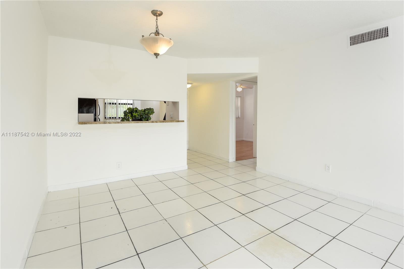 3199 Foxcroft Road, Unit 304 Miramar, FL 33025 - Photo 6 of 35 a view of a livingroom with an empty space and a ceiling fan