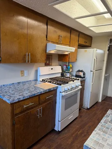 a kitchen with stainless steel appliances granite countertop a stove a sink and a refrigerator