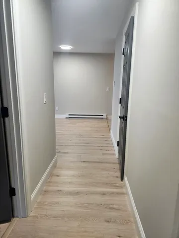 a view of hallway with stairs and wooden floor