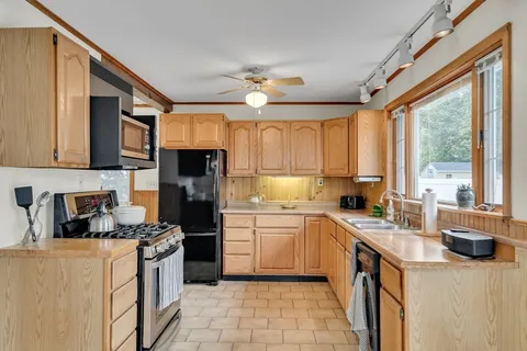 a kitchen with a sink a stove top oven and cabinets