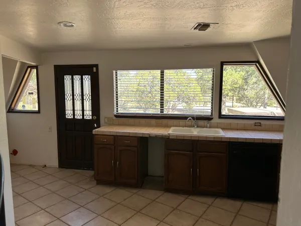 a large kitchen with granite countertop a sink and a stove top oven
