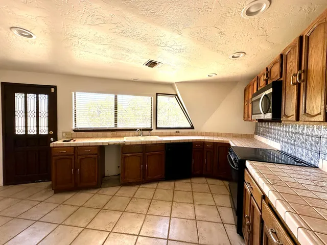 a kitchen with stainless steel appliances granite countertop a sink counter space cabinets and a large window