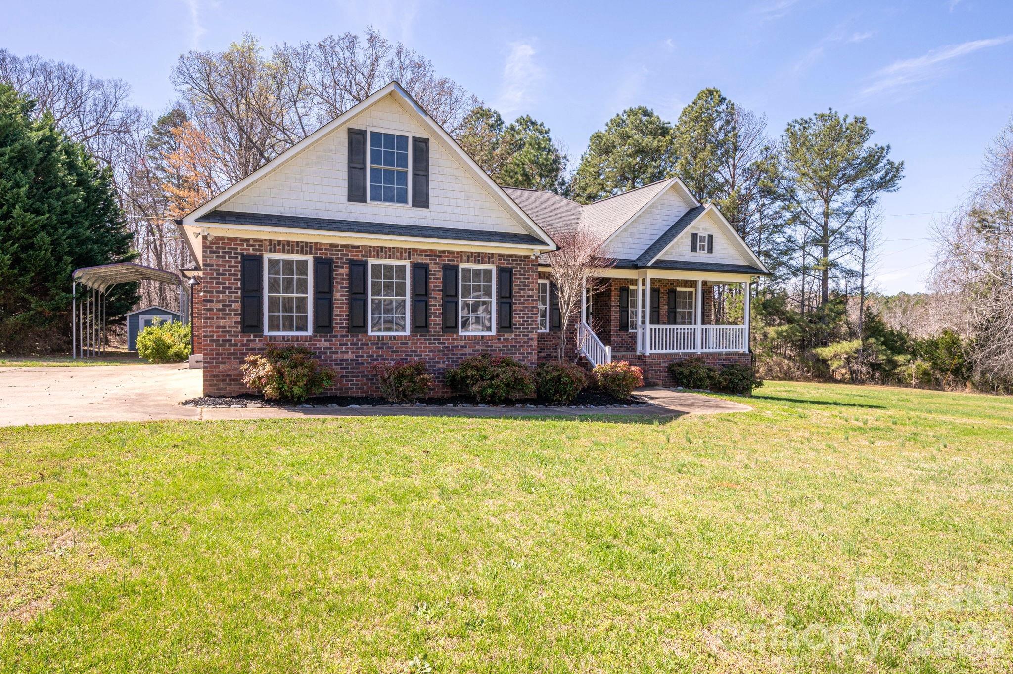 a front view of house with yard and trees in the background