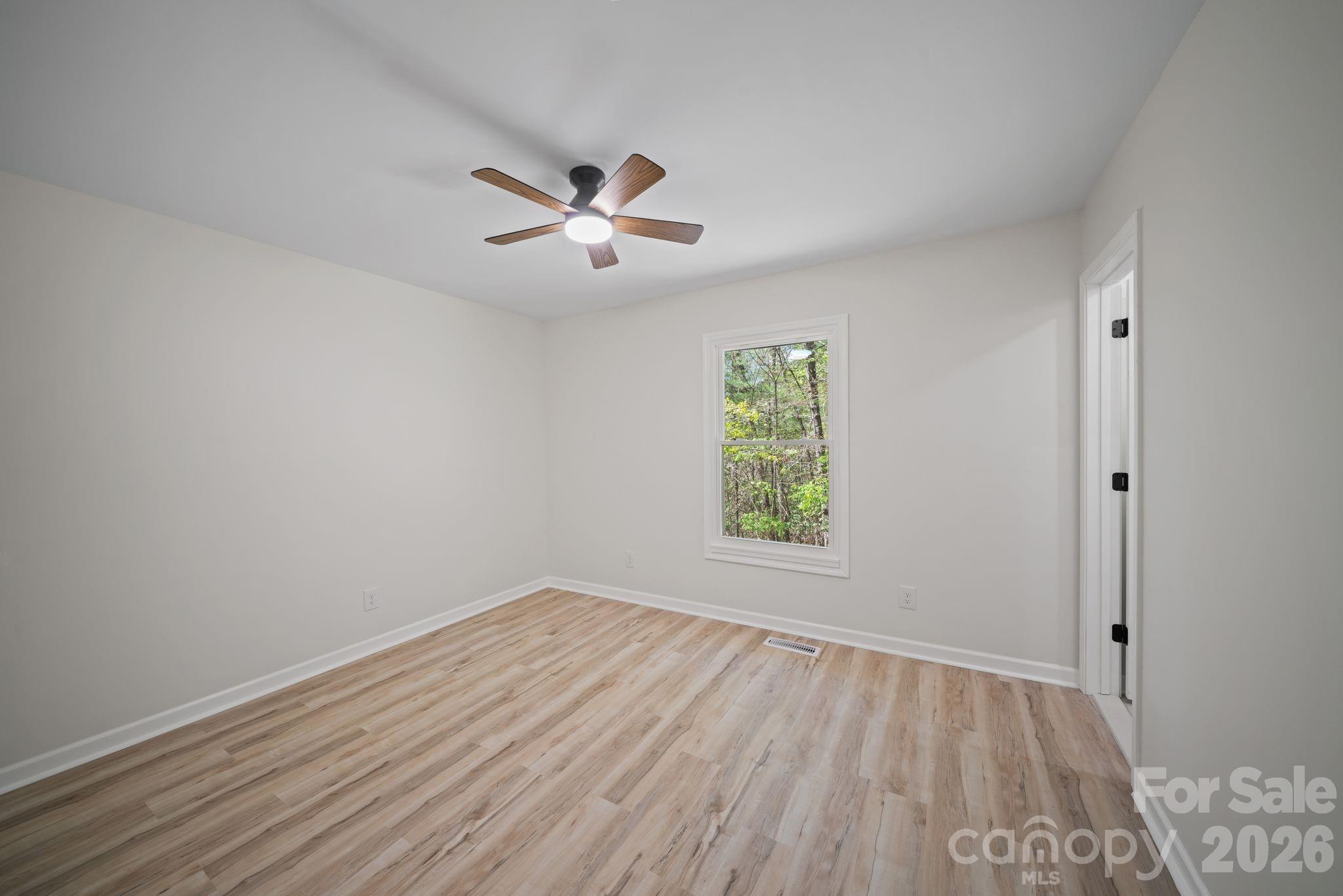 1263 See Off Mountain Road Brevard, NC 28712 - Photo 11 of 21 an empty room with a window and ceiling fan