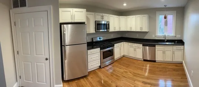 a kitchen with granite countertop a refrigerator and a sink