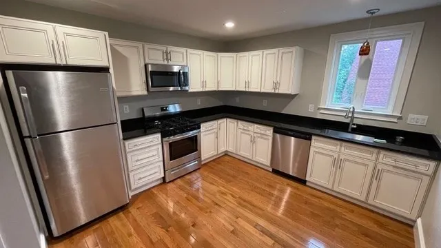 a kitchen with granite countertop a refrigerator sink and microwave