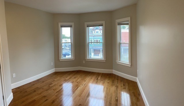 15 Dix Street, Unit 2 Boston, MA 02122 - Photo 6 of 14 an empty room with wooden floor and windows