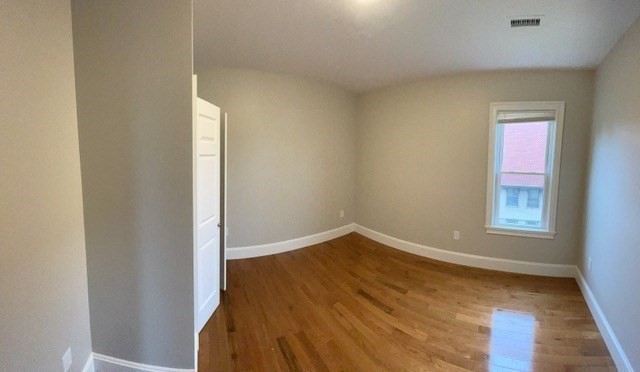 15 Dix Street, Unit 2 Boston, MA 02122 - Photo 9 of 14 an empty room with wooden floor and windows