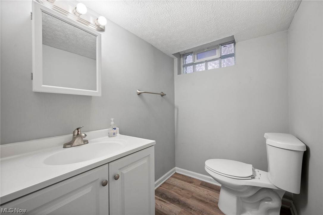 3305 Kildare Road Cleveland, OH 44118 - Photo 30 of 33 Bathroom featuring toilet, vanity with extensive cabinet space, a textured ceiling, and hardwood / wood-style floors