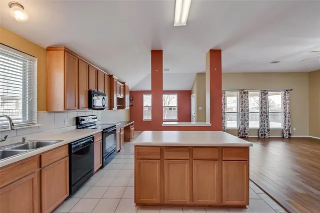 a kitchen with stainless steel appliances granite countertop a sink stove and cabinets